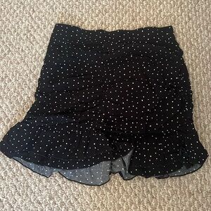 Black polka dot skirt has a ruffle at the bottom